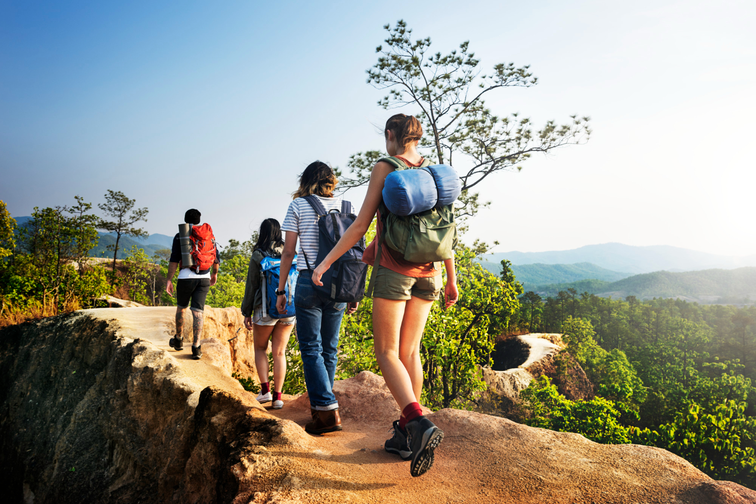 Four hikers, on a path in the morning with mountain surrounding