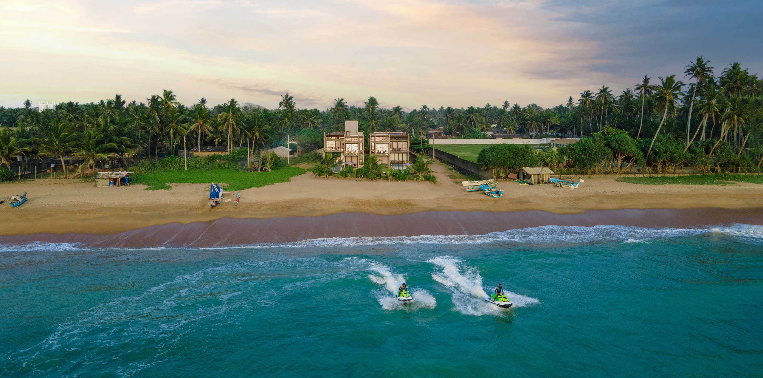 Two jet ski riders on the ocean near the Inidi Leisure beach villas in Wadduwa, Sri Lanka.