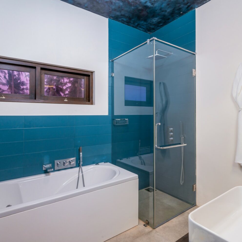 White and blue color bathroom with a bathtub, shower cubicle and a bathrobe