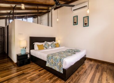 Bedroom with elegant wooden flooring and a stylish ceiling fan