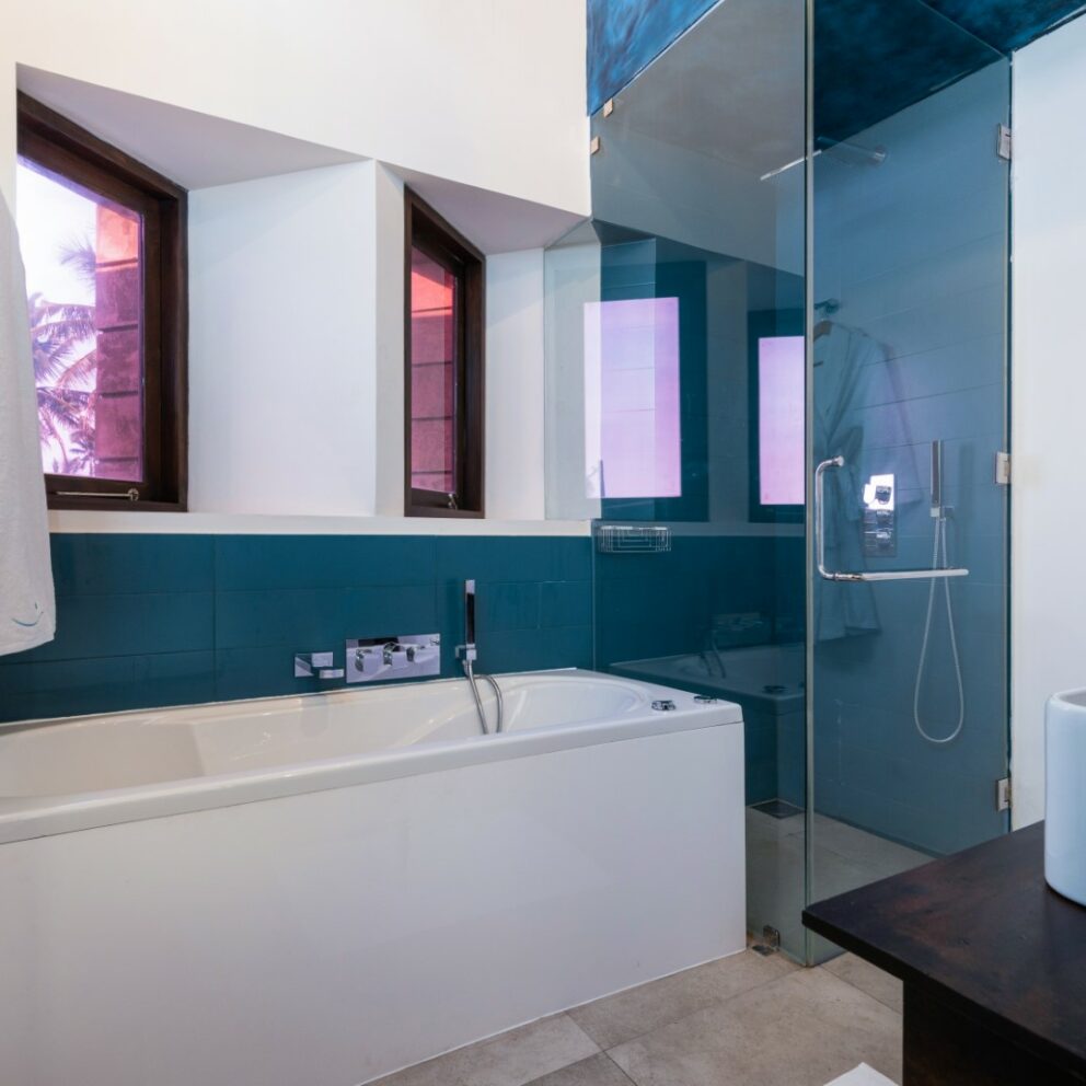 White and blue color bathroom with a bathtub, shower cubicle and a bathrobe