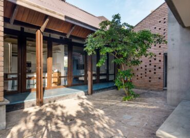 Courtyard of a villa with a medium size tree in the corner.