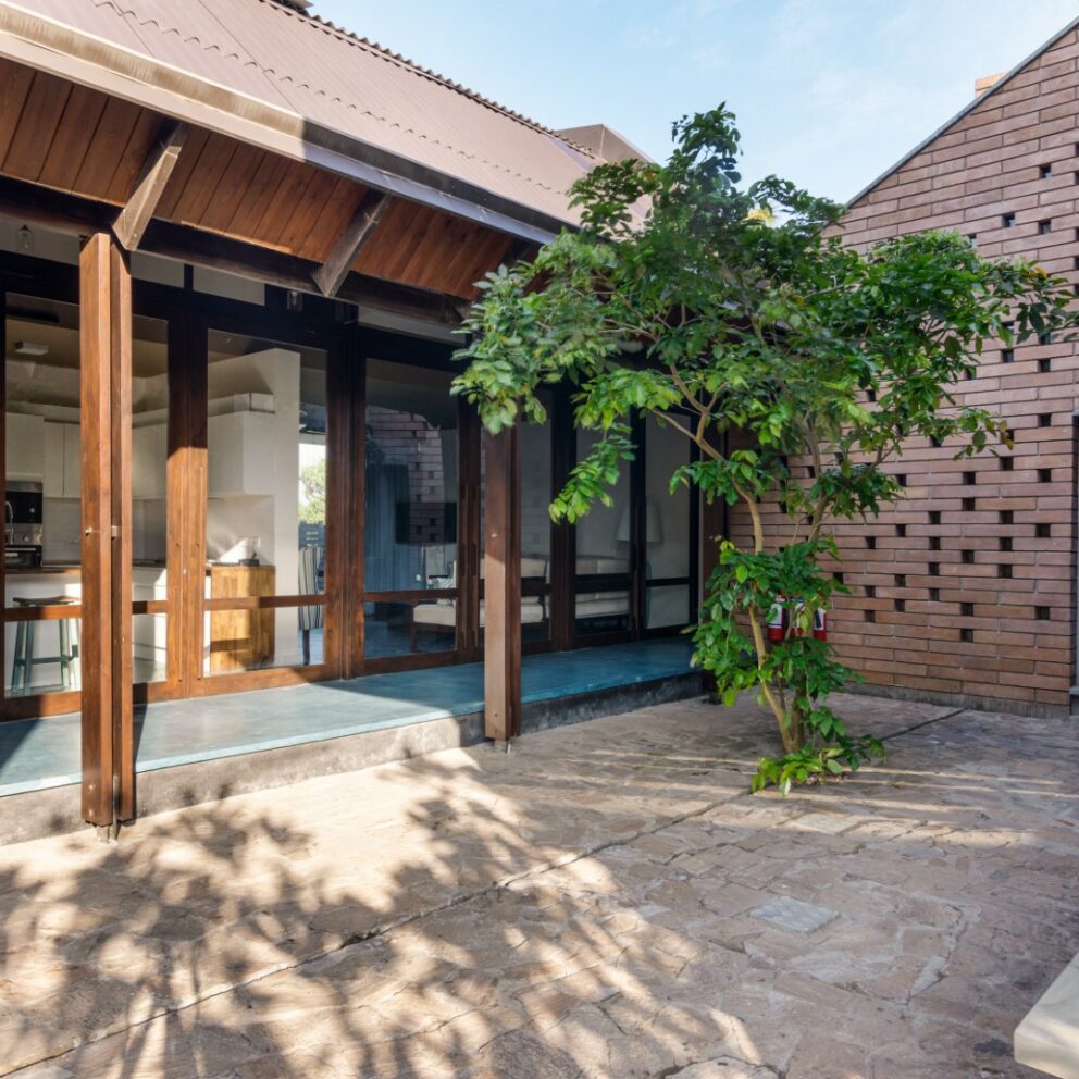 Courtyard of a villa with a medium size tree in the corner.