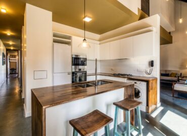 Well equipped kitchen inside the villa with a white color pantry and wood top service and cleaning area