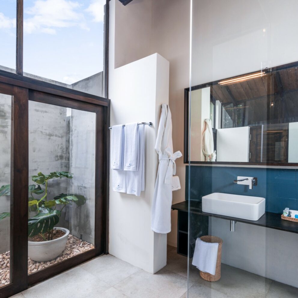 White and blue color bathroom with a bathtub, shower cubicle and a bathrobe