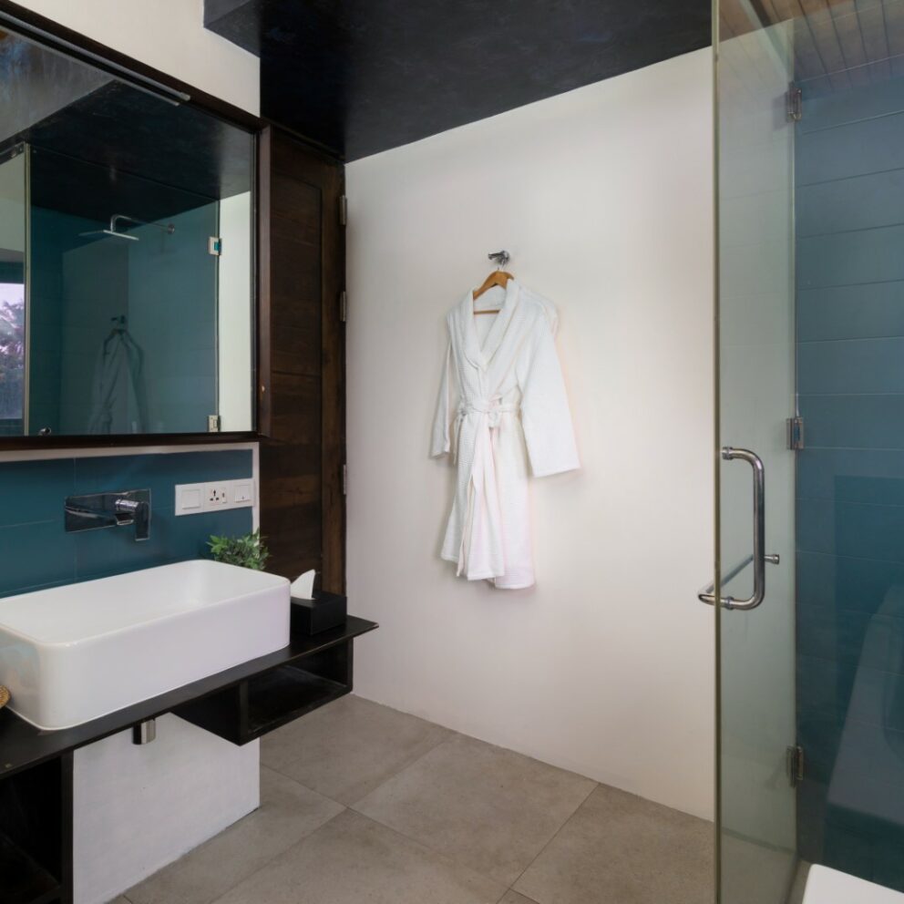 White and blue color bathroom with a bathtub, shower cubicle and a bathrobe